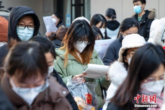 1月8日，郑州，河南省商务中等职业学校考点外，考生入场前复习。中新社发 程航 摄