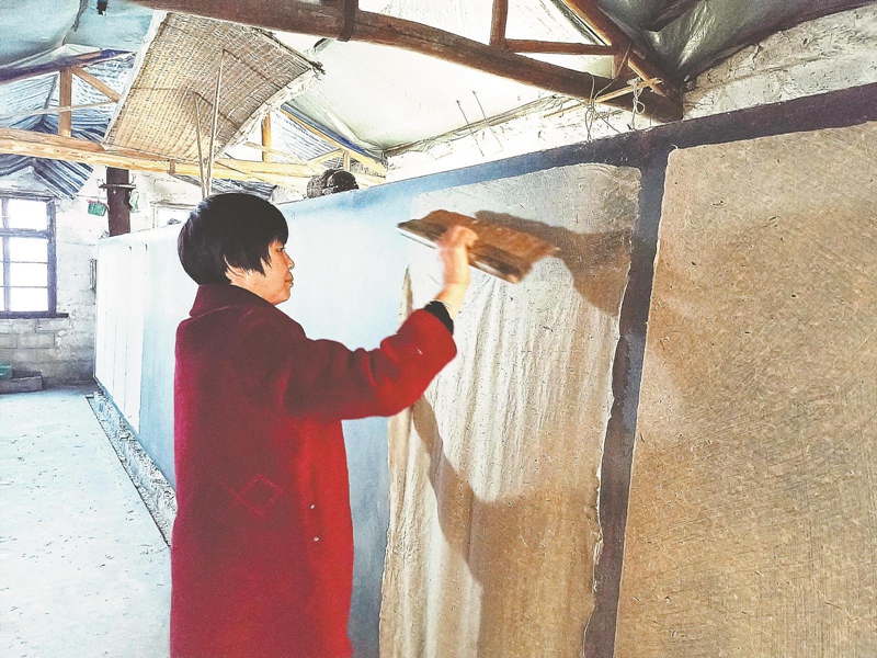潜山市杰星桑皮纸业发展有限公司工人在烘干桑皮纸。.jpg