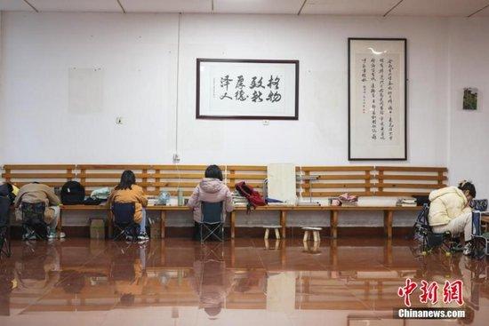 资料图:几位考研学生在南昌大学教学楼的公共空间复习备考。刘力鑫 摄